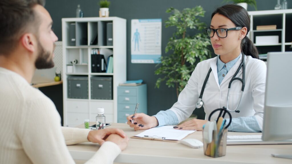 Médica conversando com paciente durante consulta sobre saúde