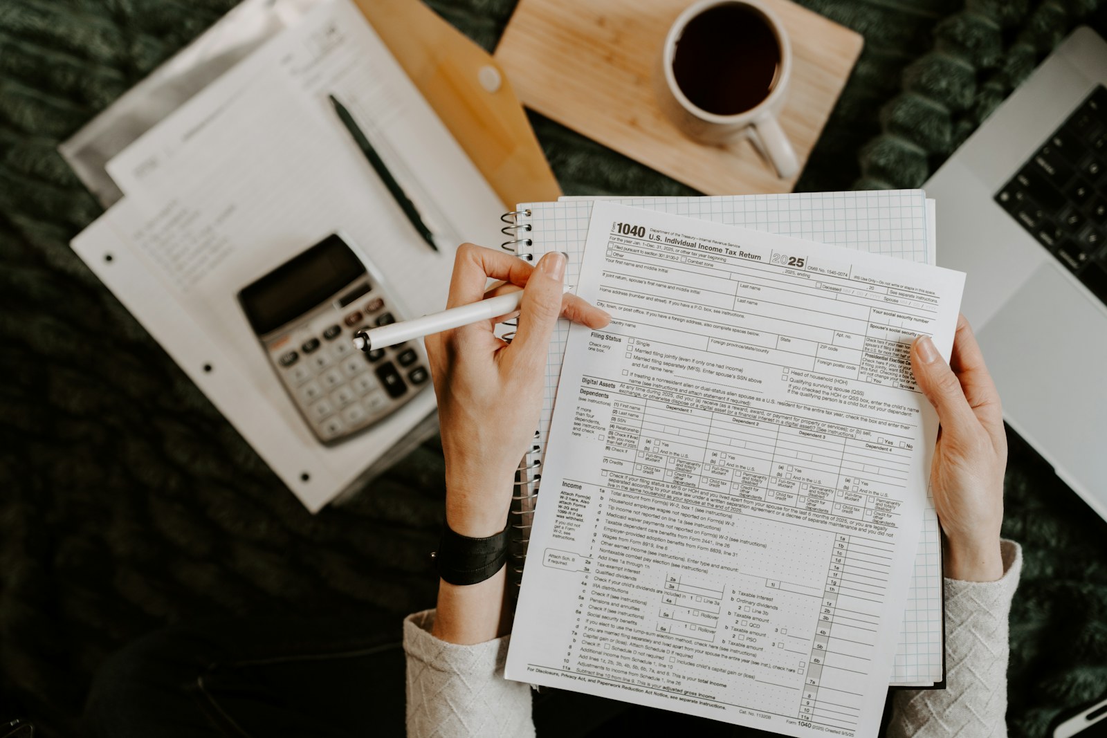 Organização de documentos com calculadora e laptop para pedido de aposentadoria
