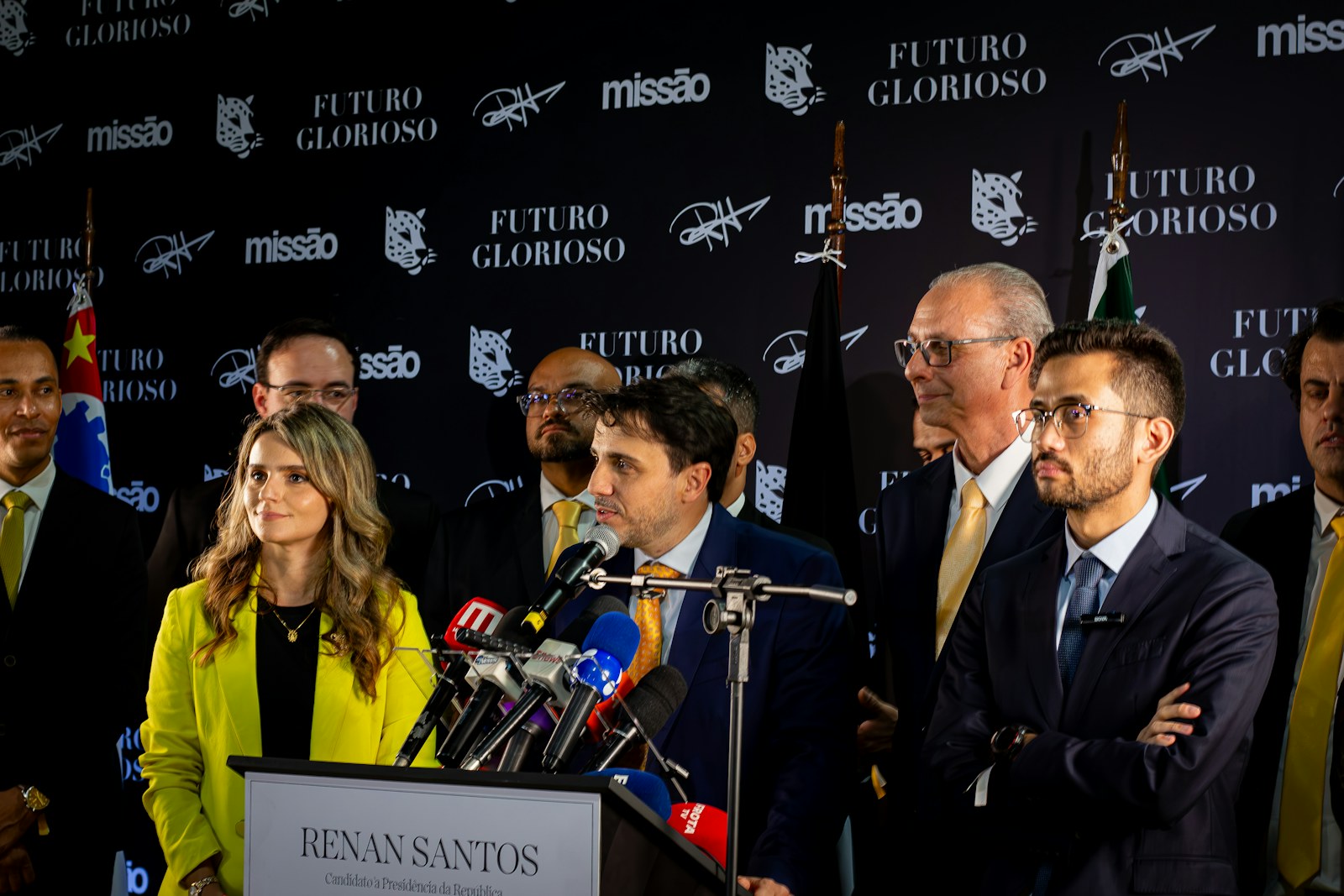 Agente político em pronunciamento público diante de microfones